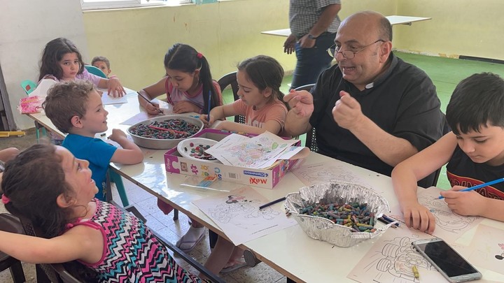 El padre Gabriel Romanelli juega con los niños que se refugian en la parroquia. Foto: Gentileza