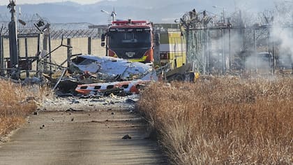 Los bomberos trabajan para extinguir un incendio en la pista del Aeropuerto Internacional de Muan