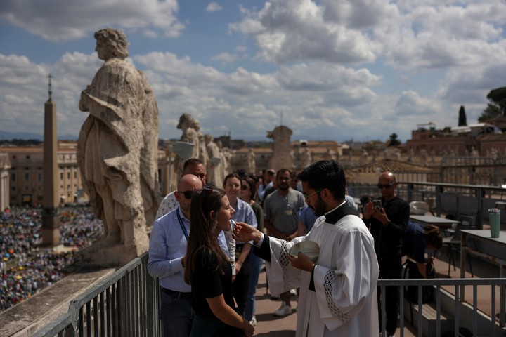 Los fieles toman la comunión durante la celebración. 