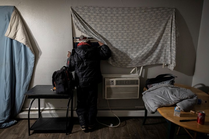 Con su valija preparada, un hombre venezolano se asoma a la ventana de su apartamento en busca de señales de agentes federales tras oír que el Servicio de Inmigración y Control de Aduanas de Estados Unidos vendrá a detener a inmigrantes para deportarlos en Aurora, Colorado, Estados Unidos, 30 de enero de 2025. REUTERS/Kevin Mohatt.