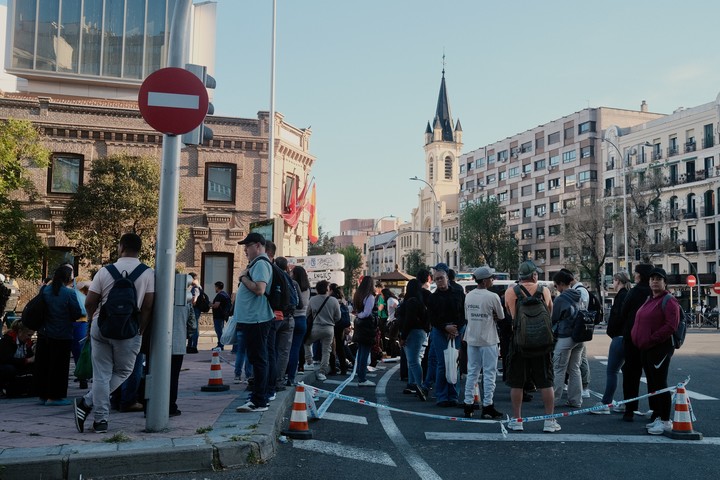 Persona sesperan en corralitos armados por la policía para evitar desbordes las paradas transporte público en Madrid. Foto: Cézaro Luca