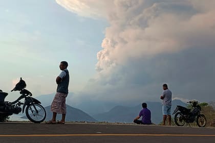 Las personas observan al volcán Lewotobi Laki Laki hacer erupción en la isla Flores.